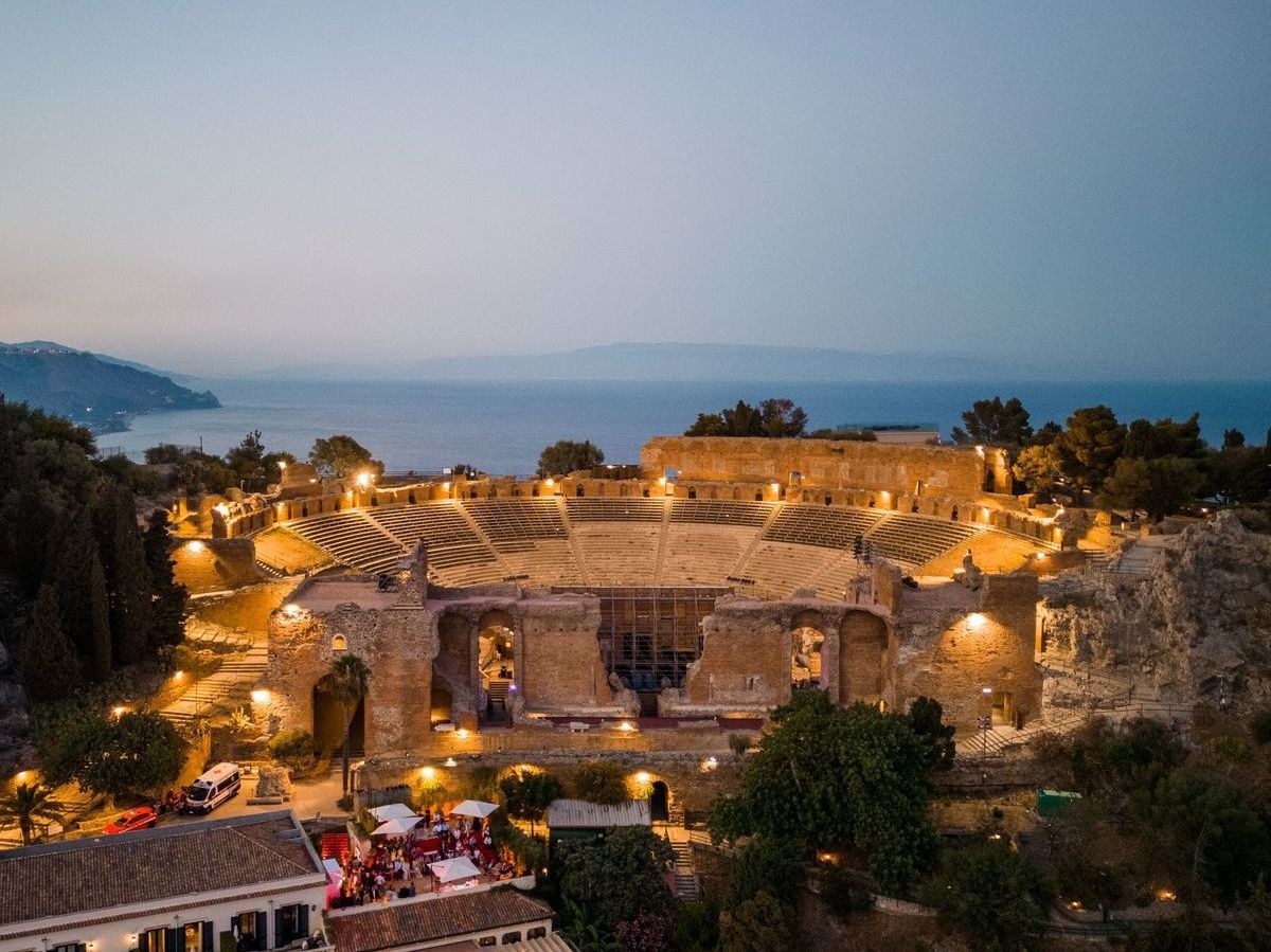 The Greek amphitheatre lit up at dusk next to Belmond Grand Hotel Timeo