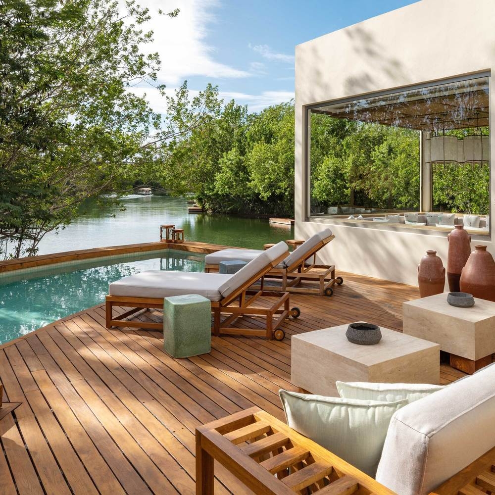 The outdoor area of one of Rosewood Mayakoba's lagoon suites, featuring a plunge pool and sunbeds.