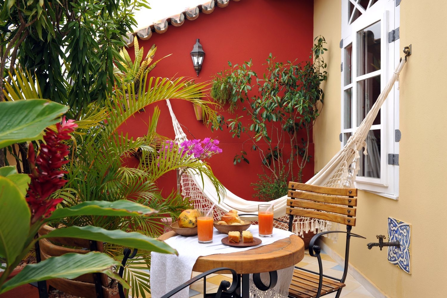 An outdoor terrace with hammock and breakfast table at Villa Bahia, Salvador