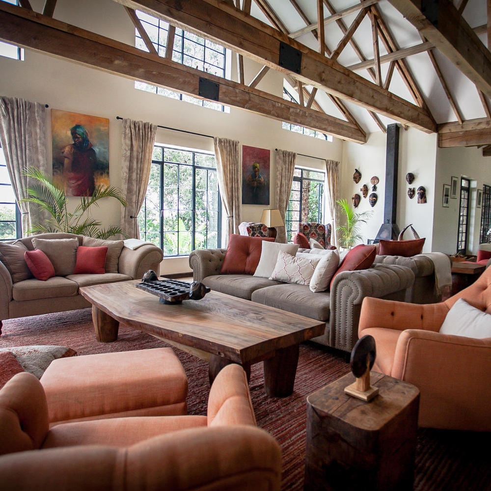 Lounge at Clouds Lodge Uganda featuring comfortable seating, a live-edge wooden table, and African masks.