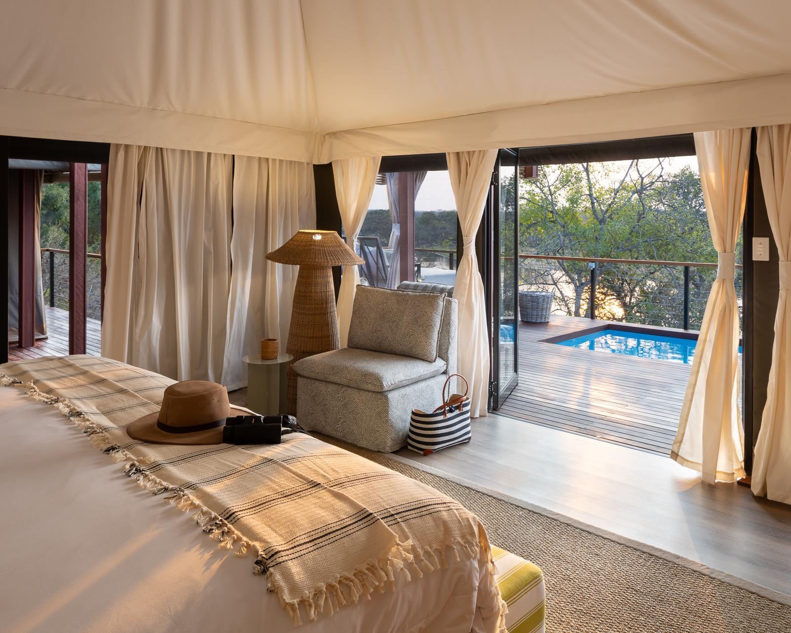 View from inside a luxury suite toward a private deck and plunge pool at Simbavati Hilltop Lodge.