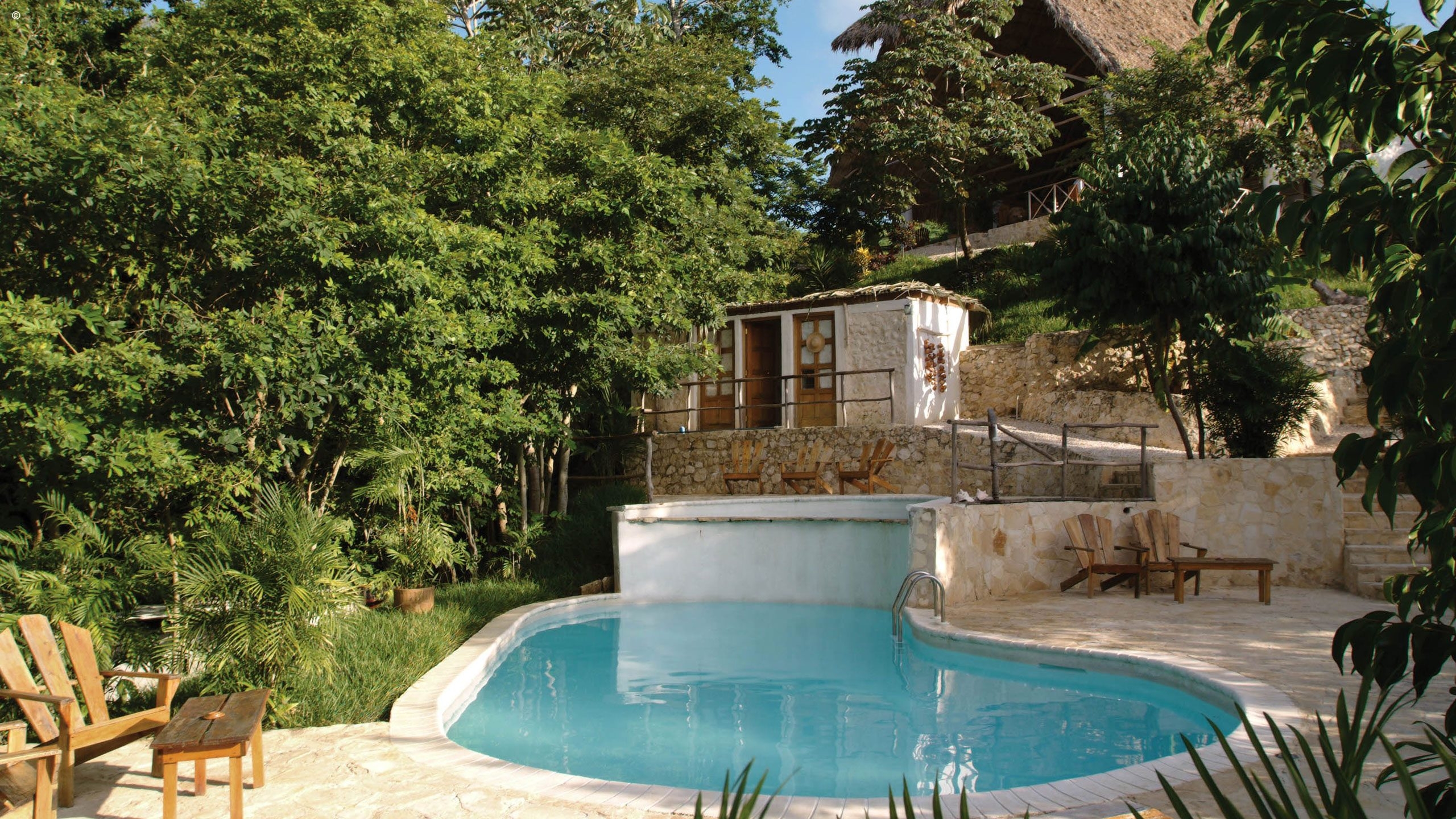 Pool area surrounded by trees at La Lancha in Tikal, Guatemala