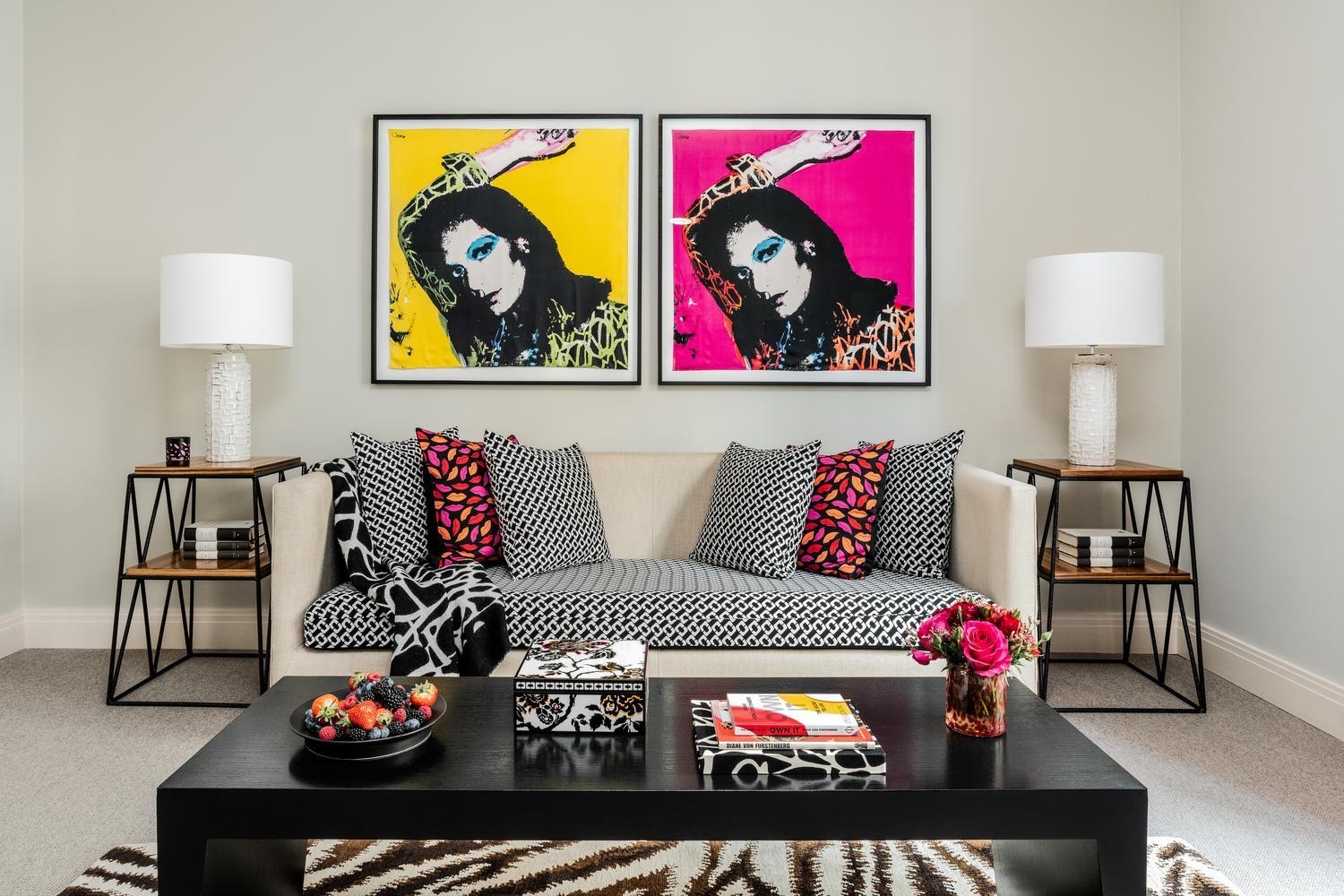 Suite living area at hotel amigo in belgium with pop-art portraits, patterned sofa, and colorful lip-print pillows.