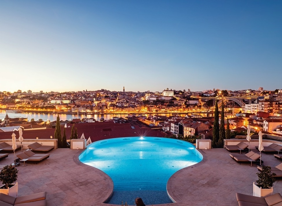 Infinity pool with terrace overlooking the city of Porto at dusk at The Yeatman hotel