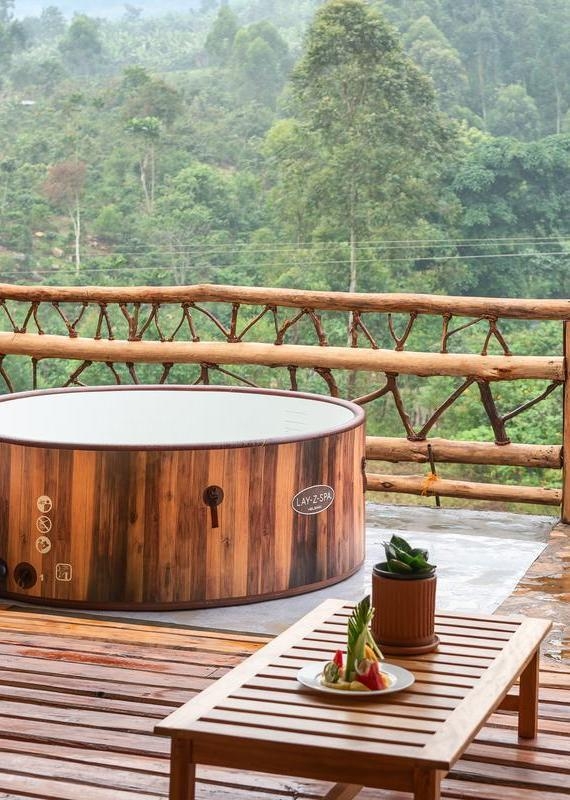 Lay-Z-Spa hot tub and a fruit platter on a wooden deck overlooking a forest at Mahogany Springs uganda.