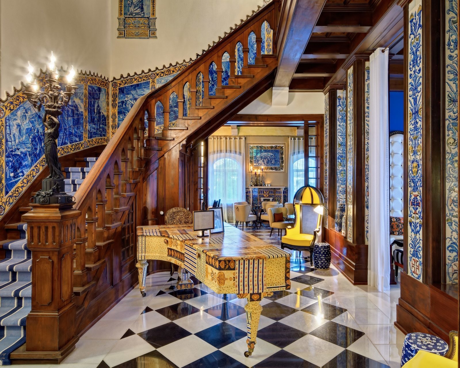 A grand piano and wooden staircase in the lobby at Hotel Bela Vista