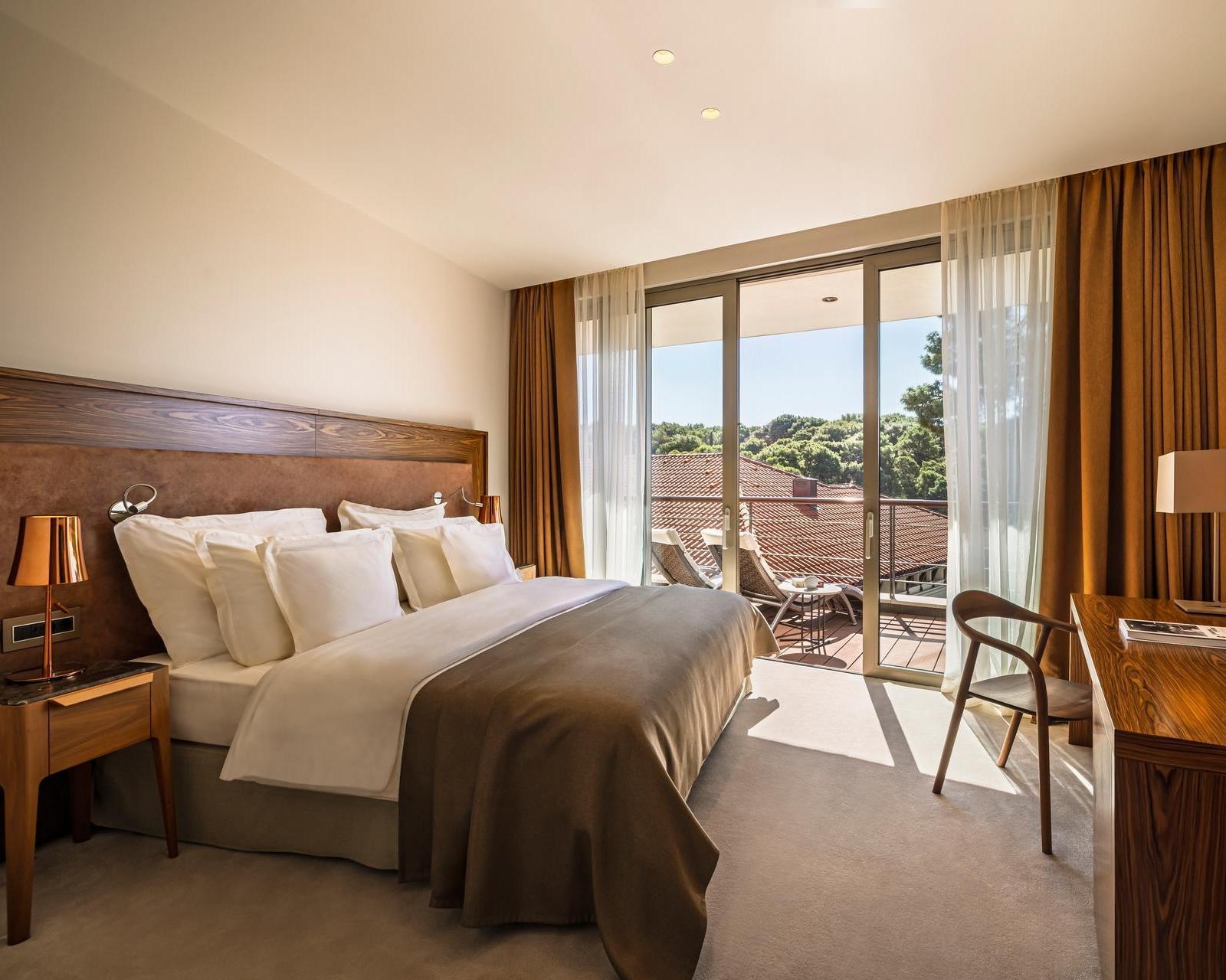A bedroom with doors leading to a balcony at Boutique Hotel Alhambra in Croatia
