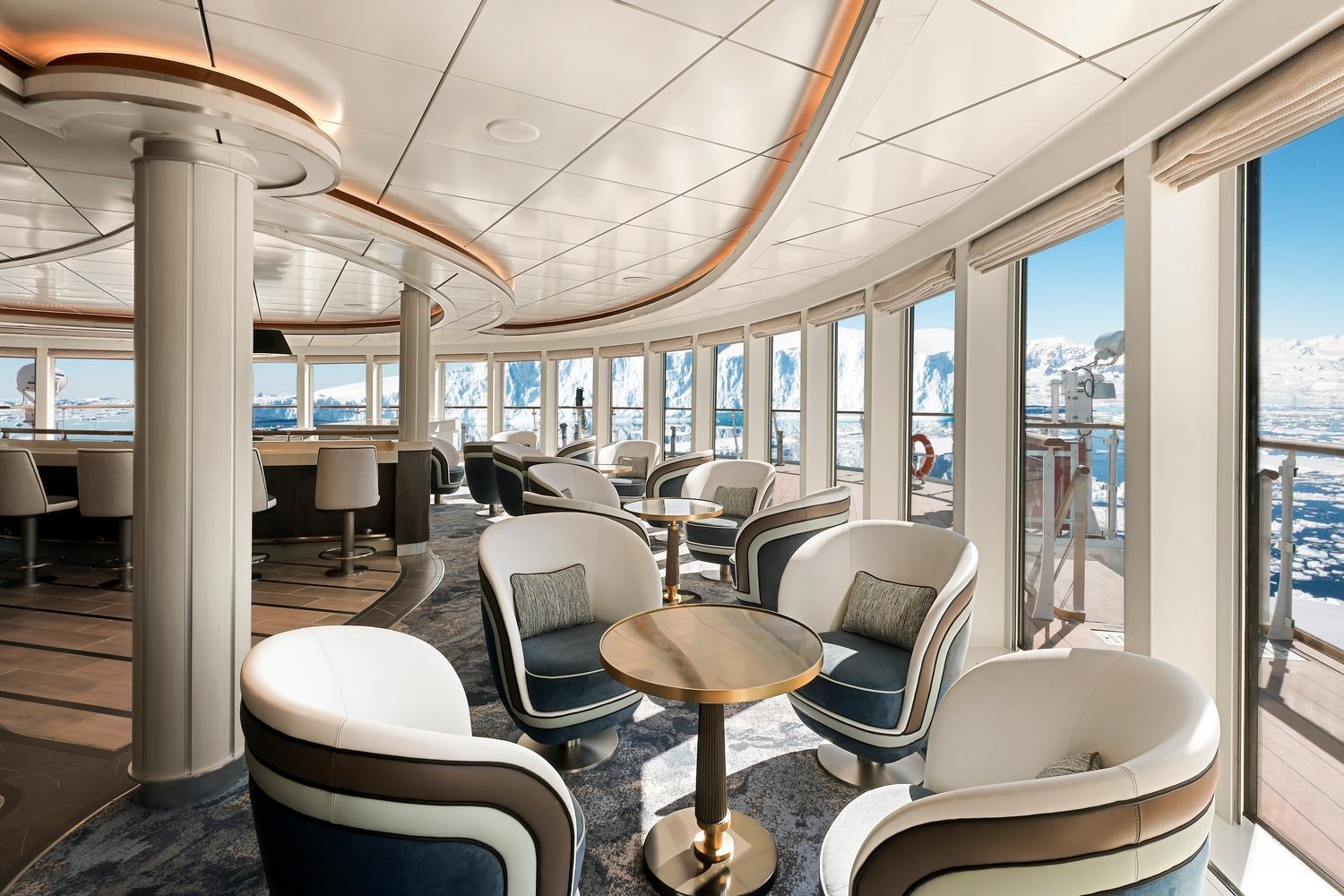 Douglas Mawson lounge with armchairs and large windows viewing icebergs.