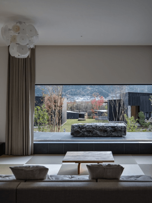 Modern sitting room with a large picture window overlooking a grassy outdoor area