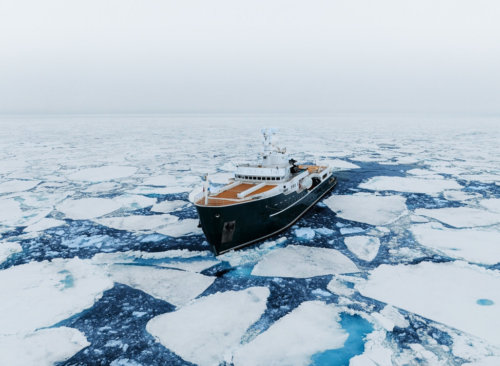 Luxury expedition cruise Aqua Lares cruising between ice.