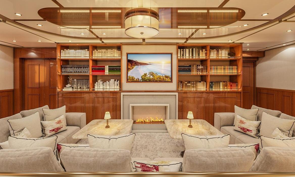 The indoor lounge of luxury expedition vessel Aqua Lares decorated with warm woods.