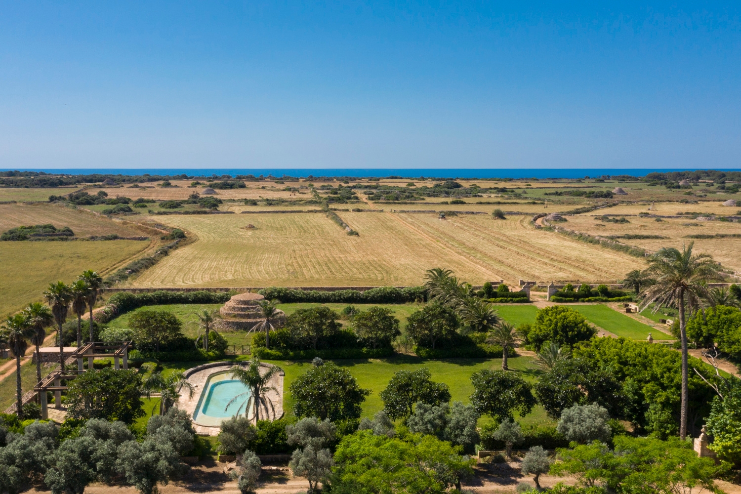 Aerial view of Son Vell in Balearic Islands Spain featuring a swimming pool, green gardens, and rural landscape.