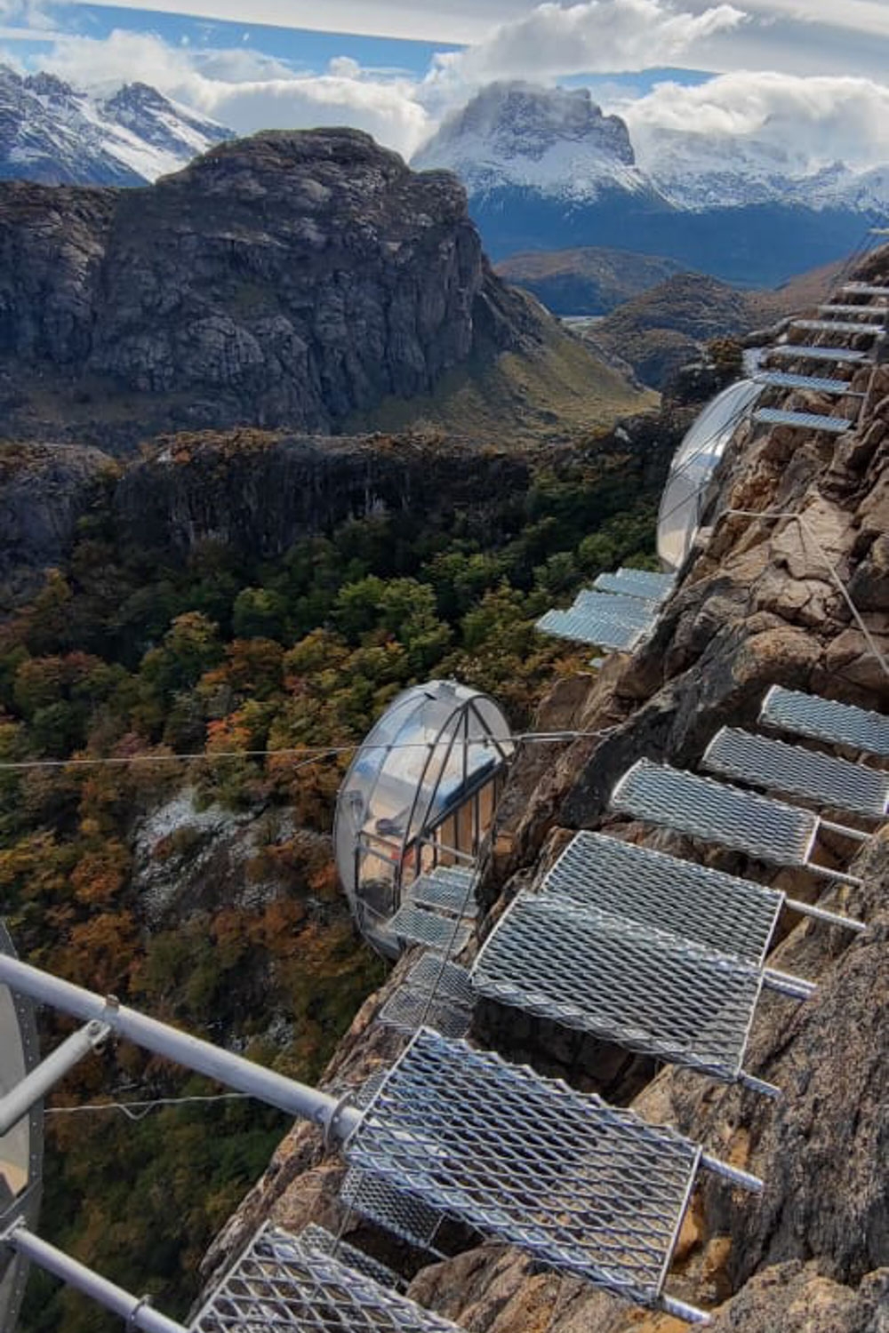 Steel steps fixed to the side of a cliff leading down to viewing pods.