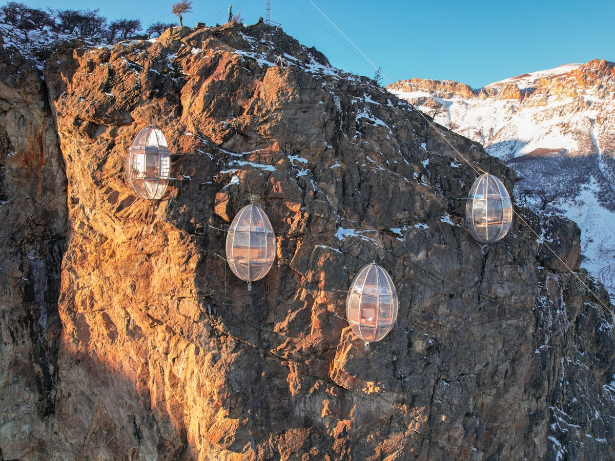 An aerial shot of four viewing pods secured to a cliff side in Argentina.