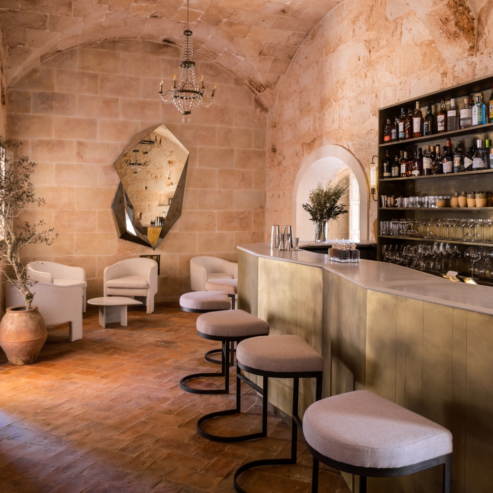 Elegant bar at Son Vell in Balearic Islands Spain featuring a brass counter and historic vaulted stone ceiling.