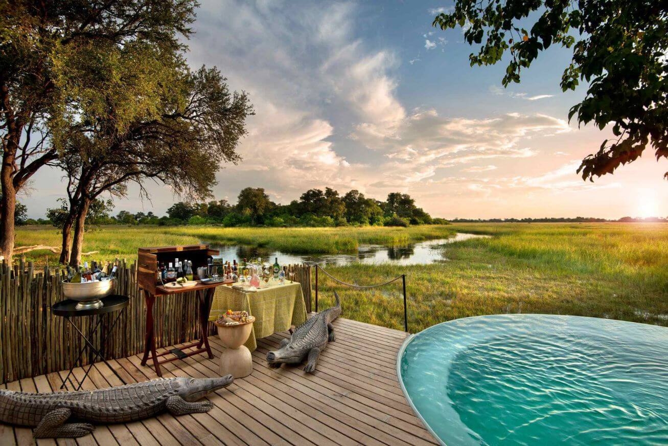 Wooden deck with drinks station and swimming pool beside a river