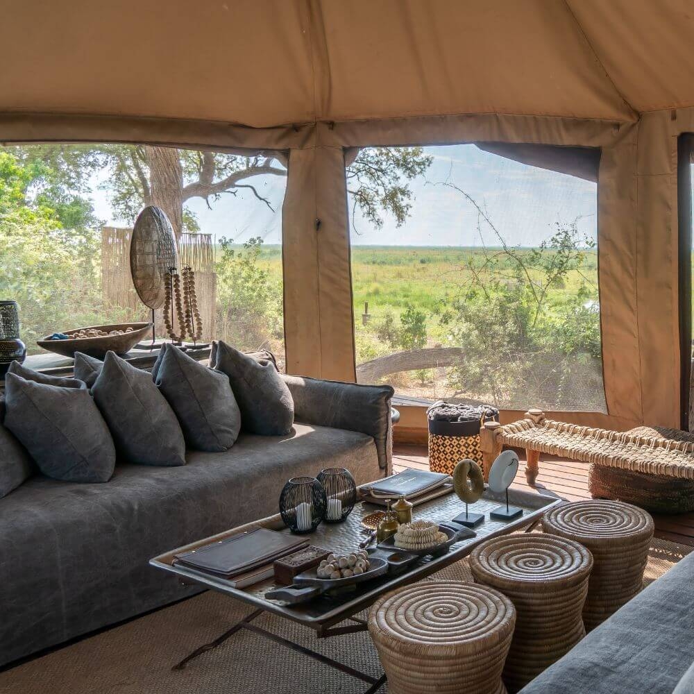 A tented lounge area with a grey sofa and coffee table