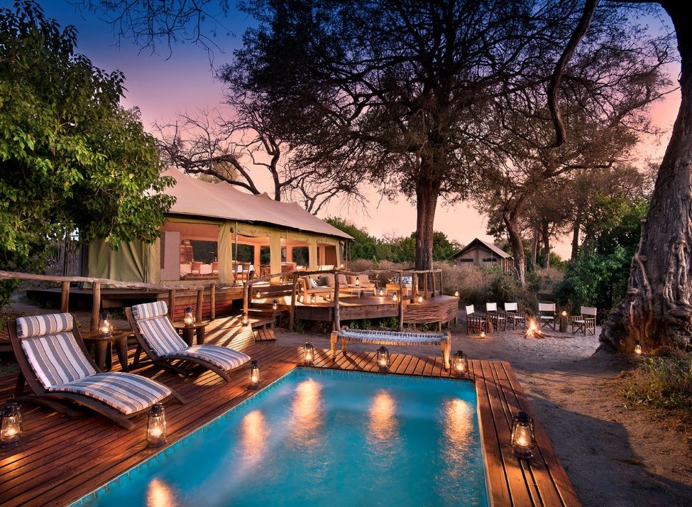 A swimming pool on a wooden deck at sunset