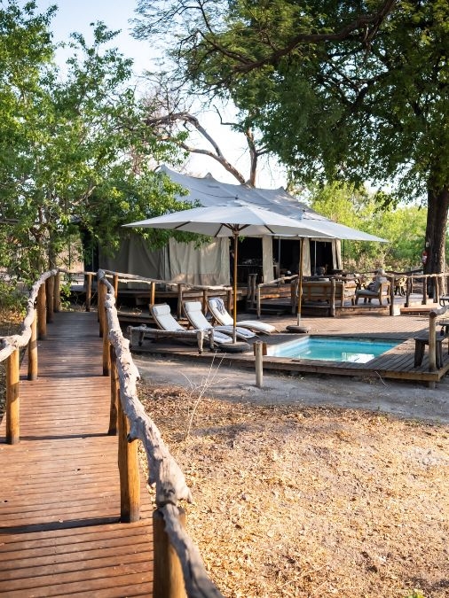 A raised wooden path leading to a pool on a wooden deck