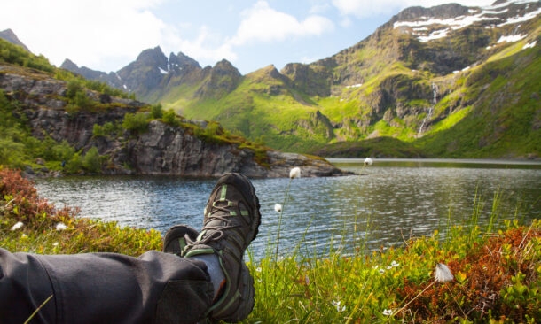 Hiker relaxing near mountain lake, Lofoten, Norway