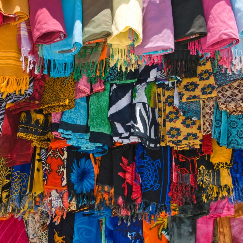 Luxury Kenya Safari Tours - Brightly coloured shawls and scarfs hanging from a stall