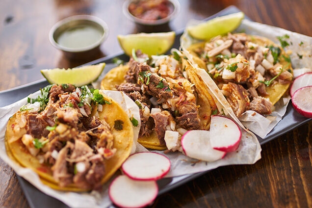 three street tacos in yellow corn tortilla with different meats