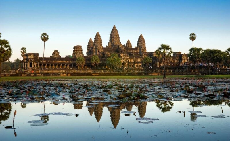 Angkor Wat, an ancient stone temple reflected in a pond during luxury Southeast Asia vacations.