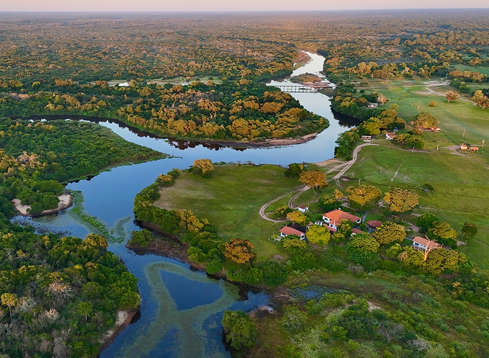 An aerial view of a lodge set beside a river in The Pantanal.