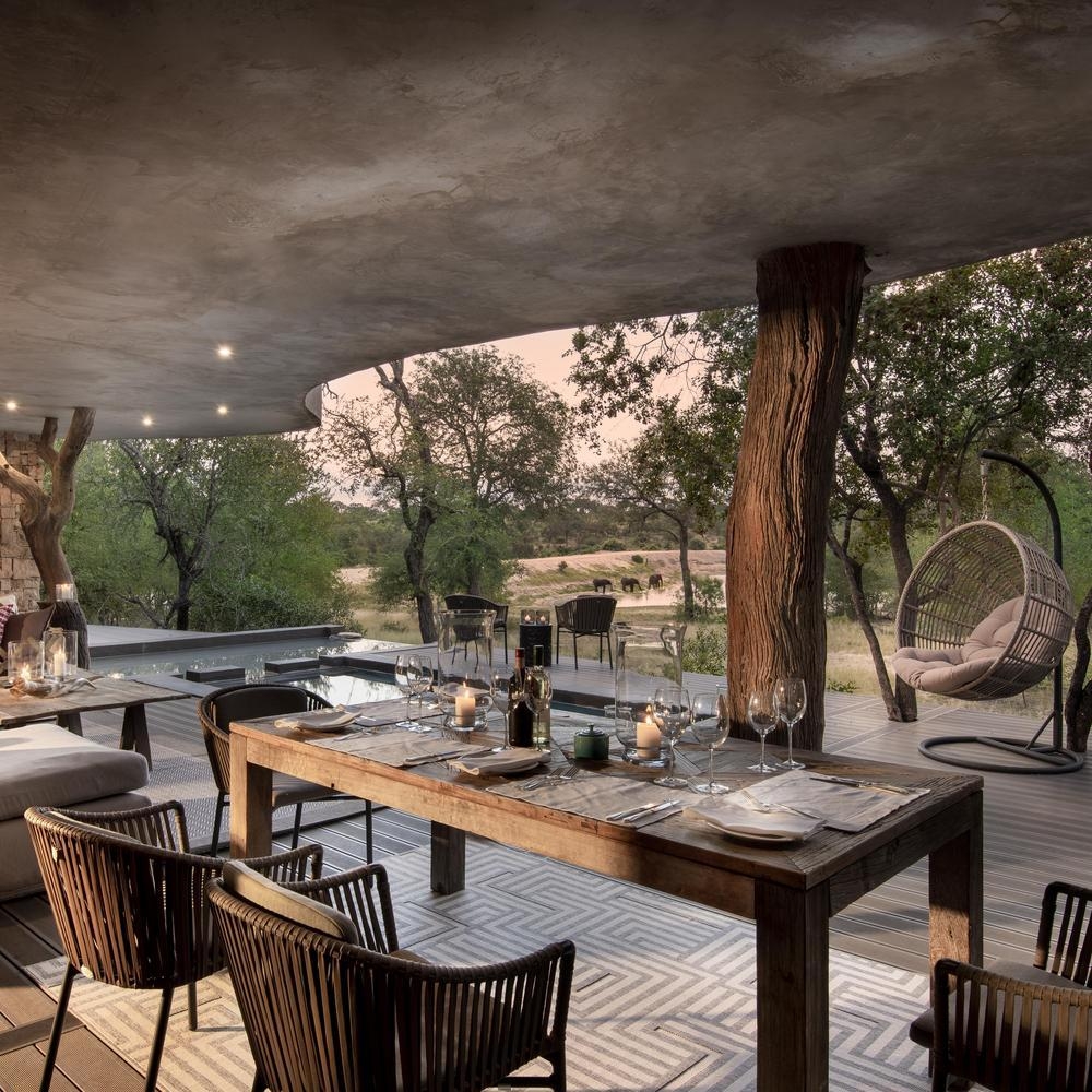 The terrace area of one of Chitwa Chitwa's accommodations, featuring a private pool, overlooking elephants in the bush.