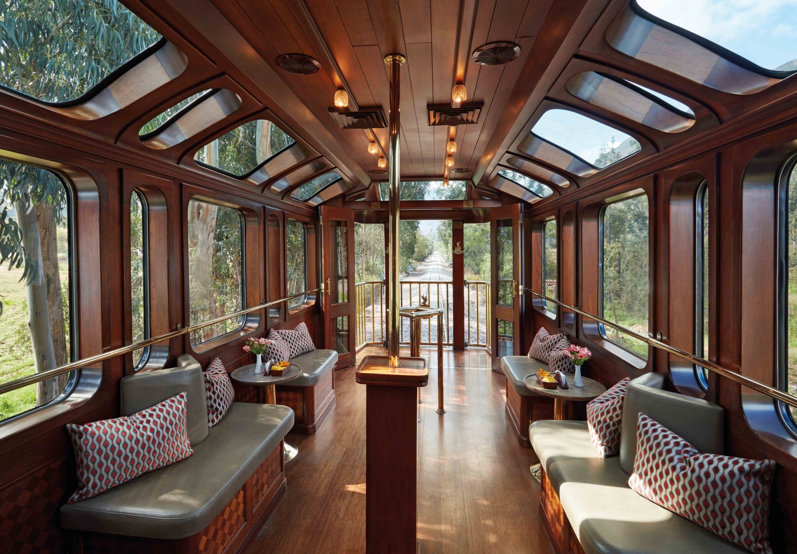 Luxurious train carriage interior with wooden panels and comfortable seating areas.