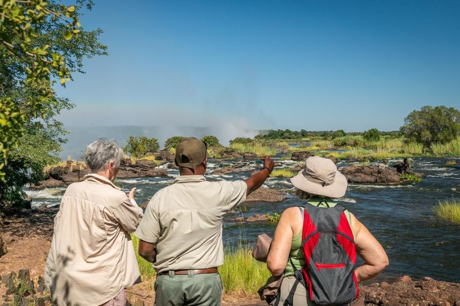 A guide with a couple at Victoria Falls.