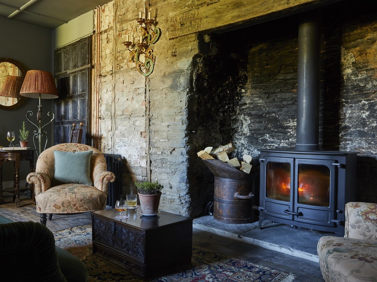 Morning room with armchairs and fireplace at The Pig at Harlyn Bay