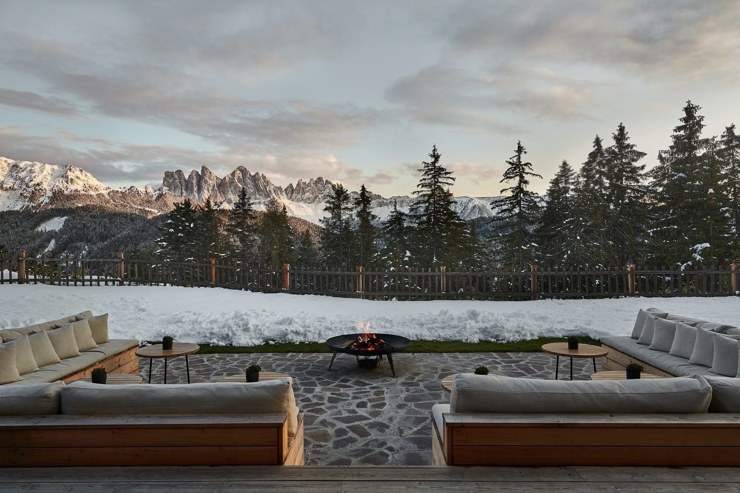 Outdoor terrace with firepit and seating at Forestis Dolomites
