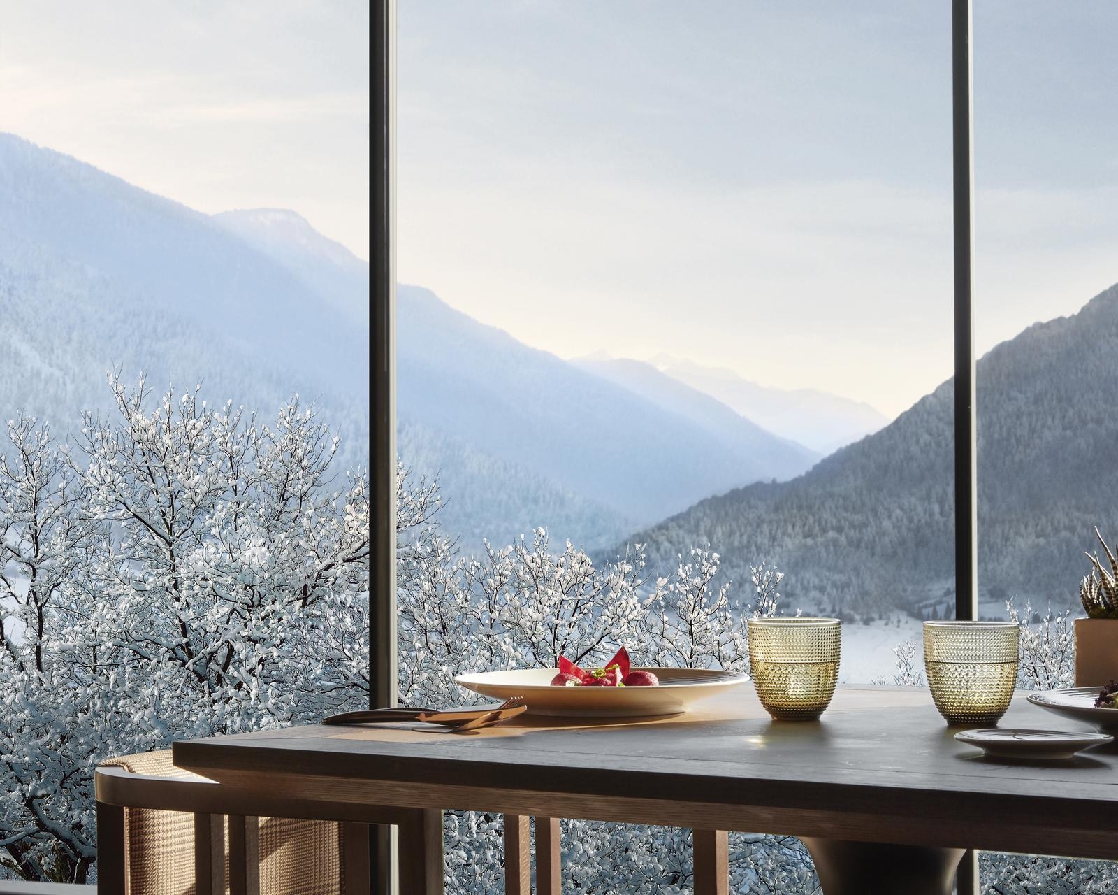 A table at Dolomia restaurant with views onto winter landscapes at Lefay Dolomiti