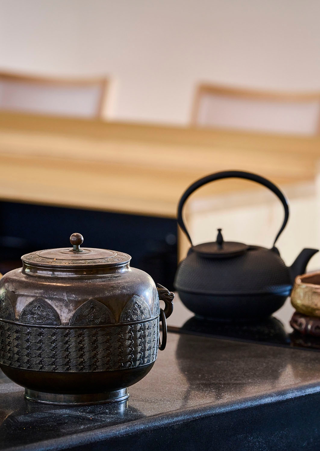 Close-up shot of a ceramic pot and teapot with decorative carvings.