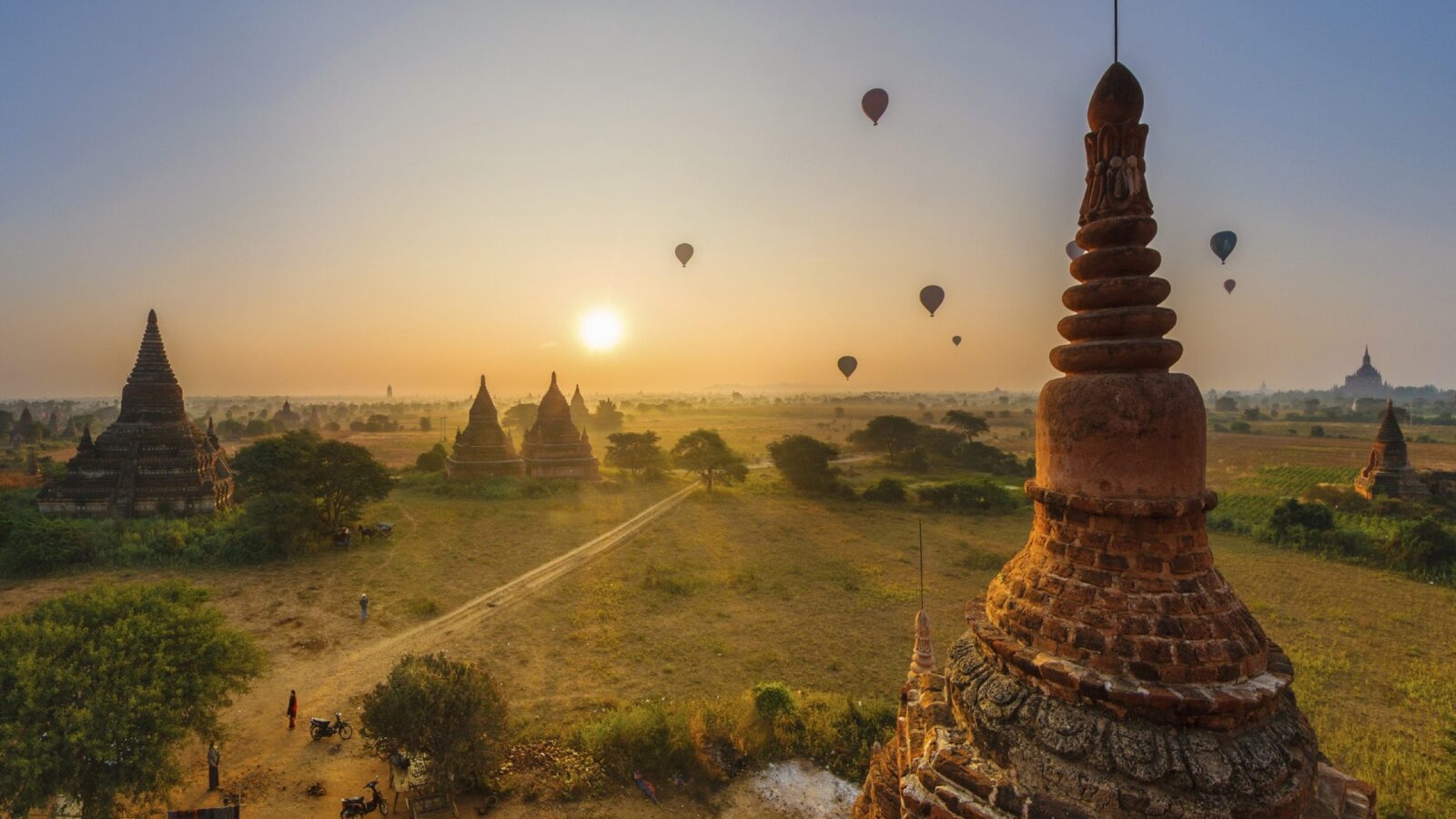 Hot air balloons drifting above a field of temples