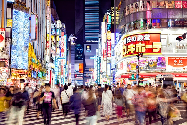 Private Japan Luxury Tours - Crowd of People Crossing big zebra crossing at night, lit by neon signs in Tokyo, Japan