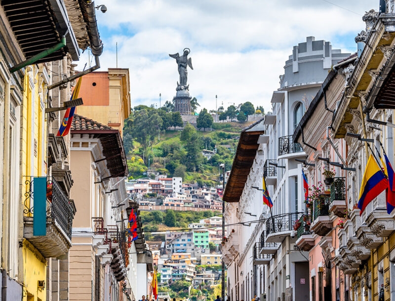 Historic street in Quito with the Panecillo statue in the background on luxury Ecuador trips.