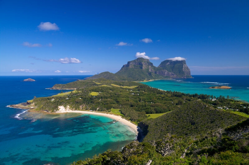 High angle view of a tropical island coastline and mountains for luxury South Pacific holidays.