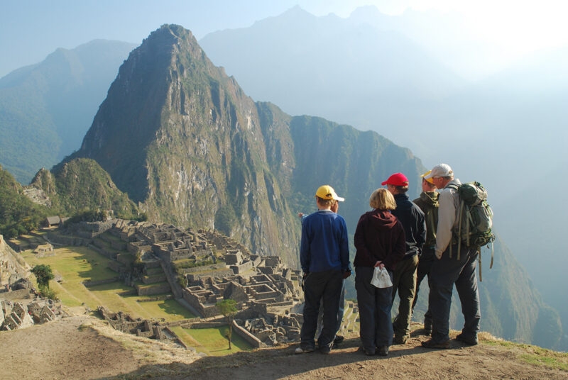 A group of people standing in front of the ancient citadel on Machu Picchu