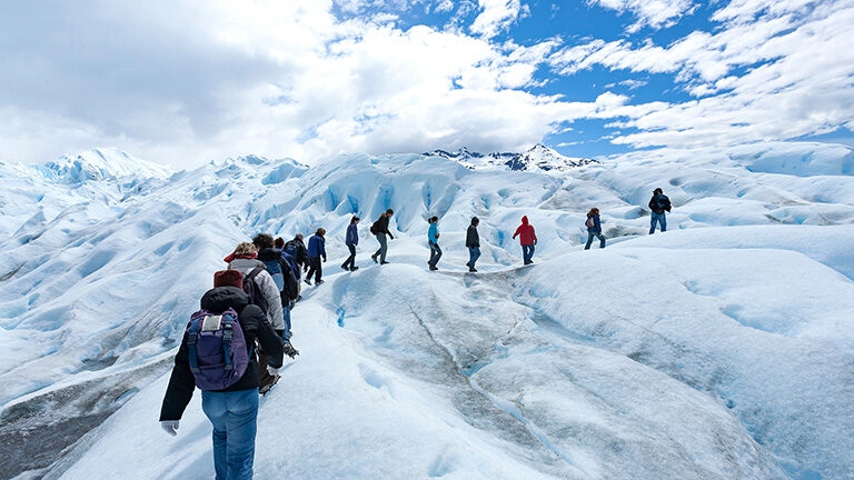A group trekking on an icy glacier