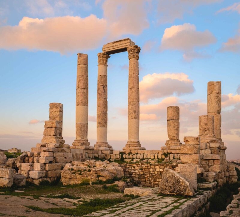 The standing columns and ruins of the Roman Temple of Hercules at the Amman Citadel in Jordan at sunset.