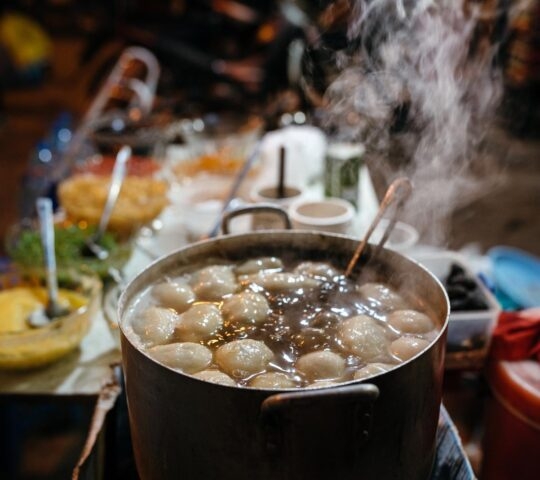 A hot Vietnamese dish is seen steaming amongst other dishes on the table
