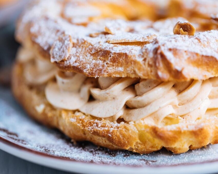 lose-up of a Paris-Brest pastry with cream filling and powdered sugar.