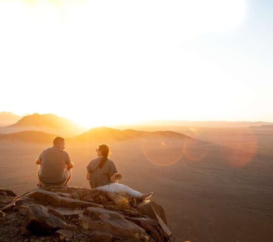 Two people enjoying the views over the Namib Desert at sunset