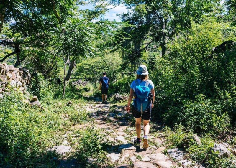 Two hikers on the ancient stone paved road from Barichara to Guane called "El Camino Real". , Barichara/ Colombia/ South America