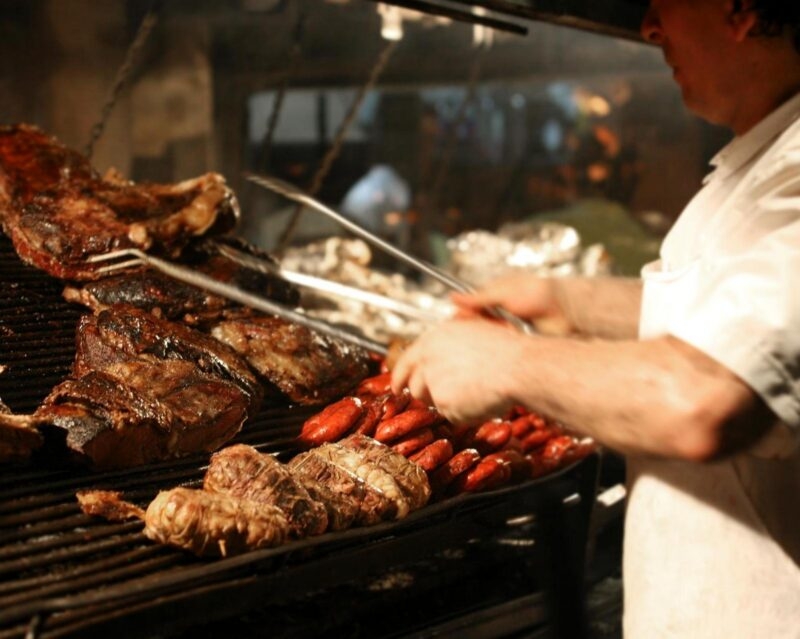 Argentinian chef cooking meat on a grill