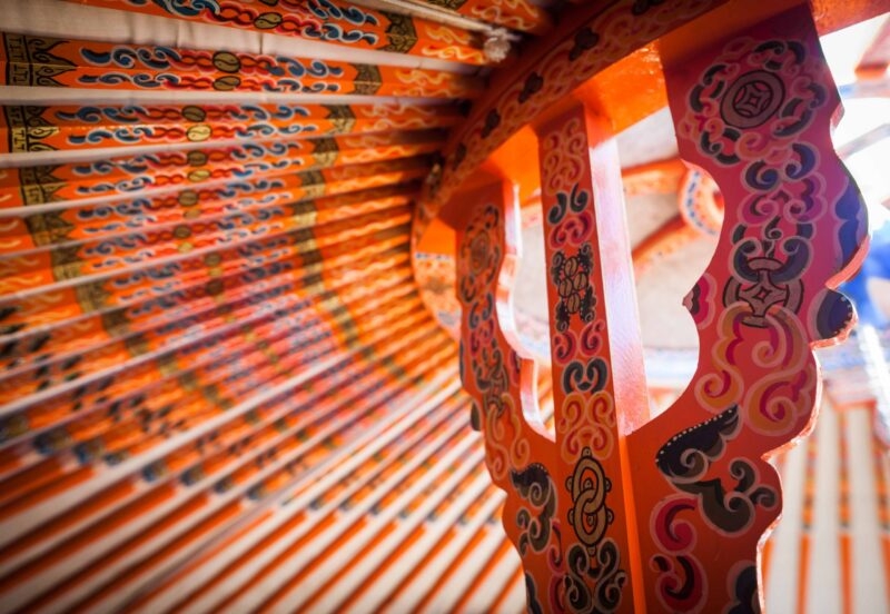 Painted orange wooden roof structure inside a yurt, a cultural feature of luxury Mongolia holidays.