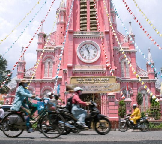 Pink Catholic Church and traffic in Ho Chi Minh City / Saigon, Vietnam