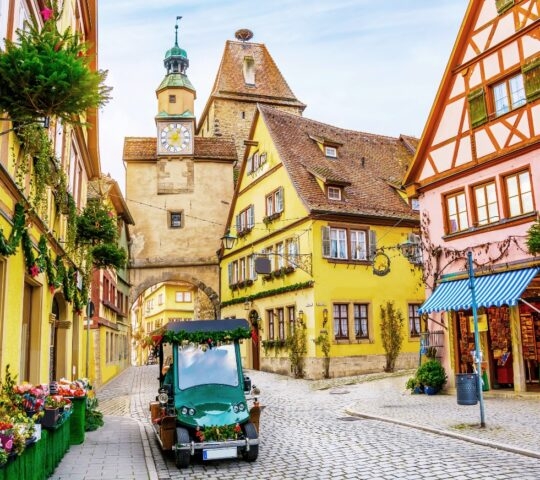Touristic retro car on picturesque street, decorated for Christmas holiday in Rothenburg ob der Tauber, picturesque medieval historic town in Bavaria, Germany